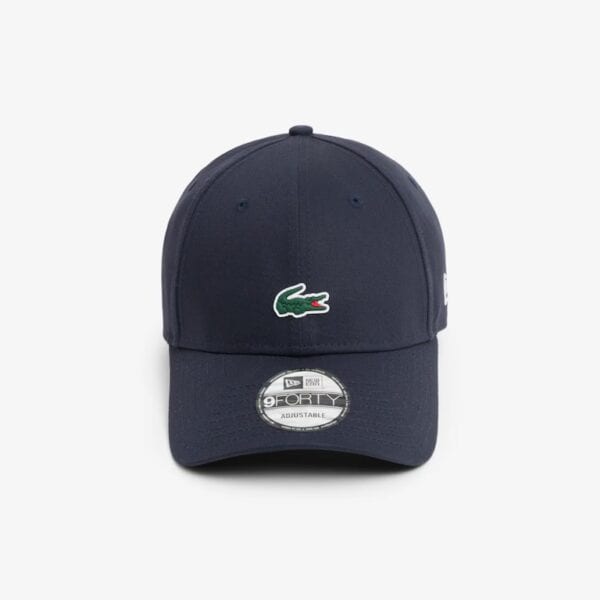 Lacoste x New Era Cap in dunklem Blau mit grün-weißem Krokodil-Logo, sportlich und modisch, perfekt für Casual Looks.