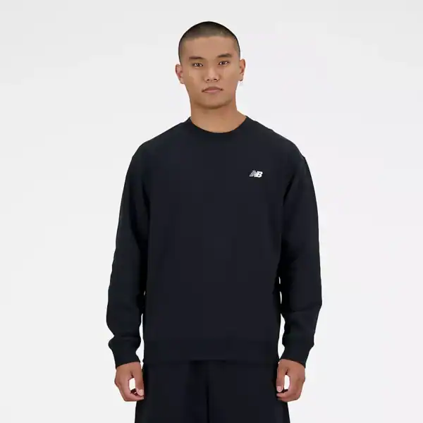 Mann trägt schwarzen New Balance Crew Logo Pullover, schlichtes Design, sportlich, bequem, ideal für Freizeit und Sport.