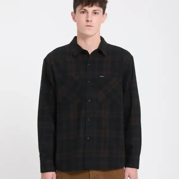 Männlicher Model trägt ein braunes, kariertes Flanellhemd von Volcom Hunkstone in Cacao, perfekt für den Casual-Look.