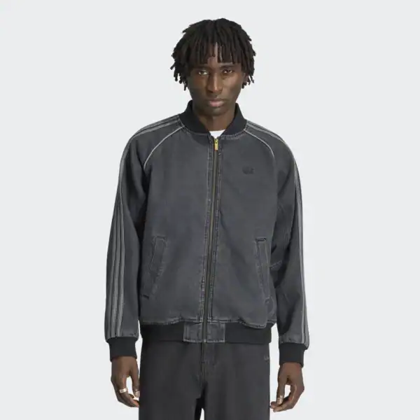 Mann trägt eine schwarze Vintage Adidas Denim Jacke IB6948 mit Reißverschluss und Rippbündchen, stilvoller Streetwear-Look.