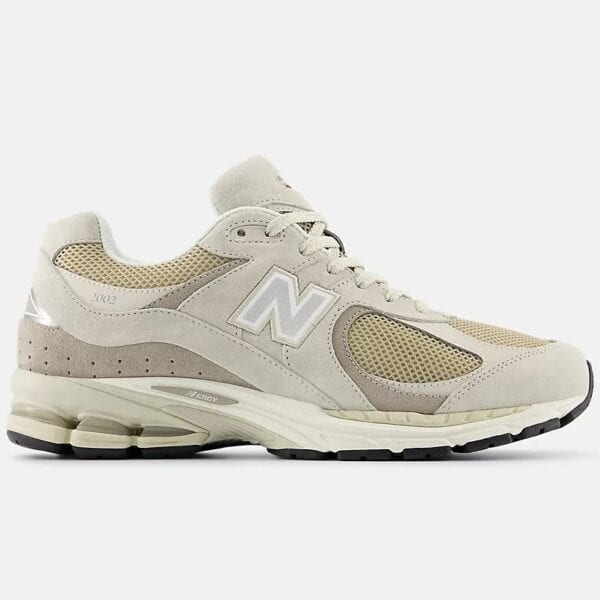 Beige und grüne New Balance 2002 RB Sneaker mit Mesh- und Leder-Details, seitliche Ansicht, auf weißem Hintergrund.