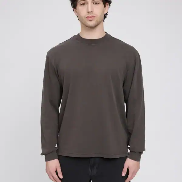 Männlicher Model trägt ein braunes Longshirt aus Bio-Baumwolle, schlichtes Design, perfekt für nachhaltige Mode, auf weißem Hintergrund.