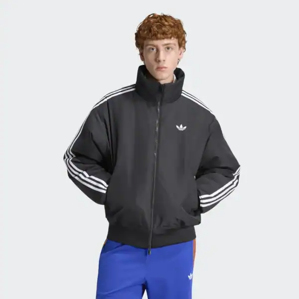 Mann trägt schwarze Adidas Firebird Winterjacke KR7203 mit weißen Streifen an den Ärmeln, sportliches Outfit, modisch und funktional.