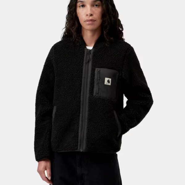 Dame trägt schwarze Carhartt Wip Fleecjacke mit Reißverschluss und Brusttasche, modisch und bequem für den Alltag.