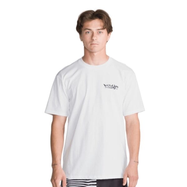 Männlicher Model trägt ein weißes Volcom Framer T-Shirt, das bequem und modisch aussieht, perfekt für sportliche Freizeitaktivitäten.