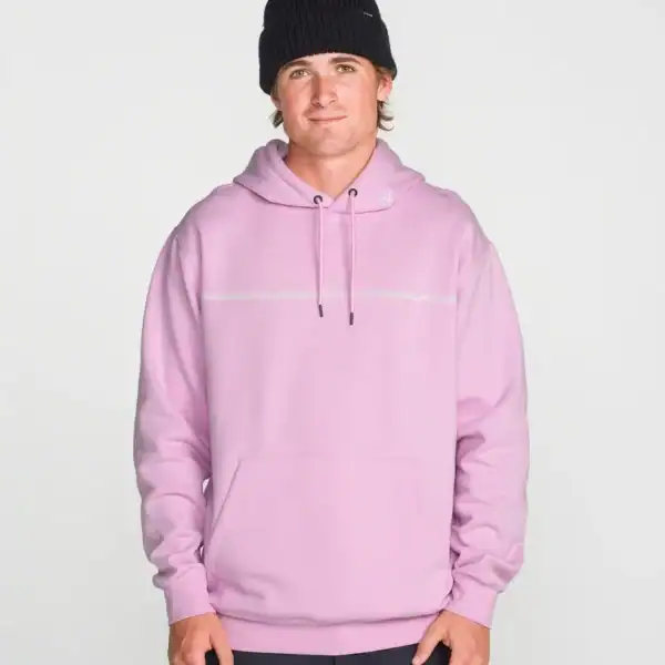 Junger Mann trägt einen pinken Kapuzenpullover mit schwarzem Beanie, lässig vor hellem Hintergrund.
