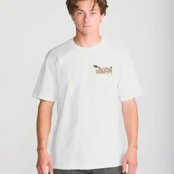 Junger Mann trägt das weiße Volcom Zombeach Loose Fit T-Shirt mit Logo-Print auf der Brust, ideal für Surf- und Strandliebhaber.